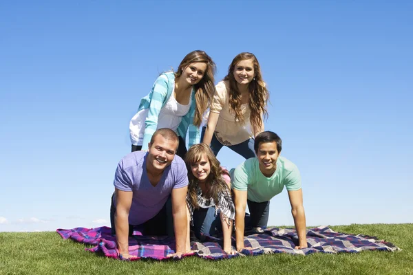 Jeunes amis faisant une pyramide humaine — Photo