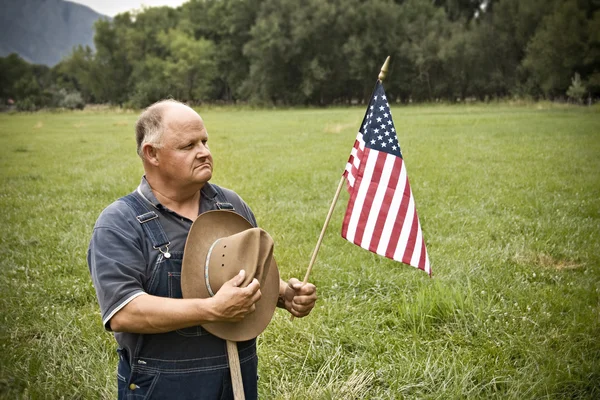 Antigo agricultor segurando a bandeira dos EUA — Fotografia de Stock