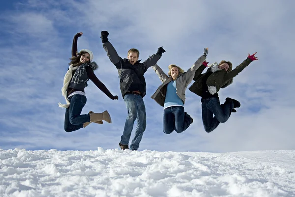 Jovens pulando na neve — Fotografia de Stock