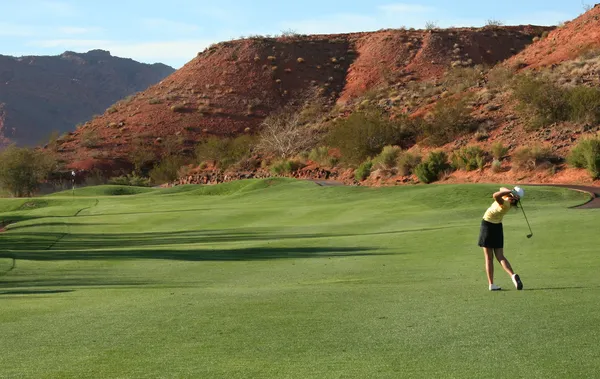 Kvinna som spelar golf på öken kurs — Stockfoto