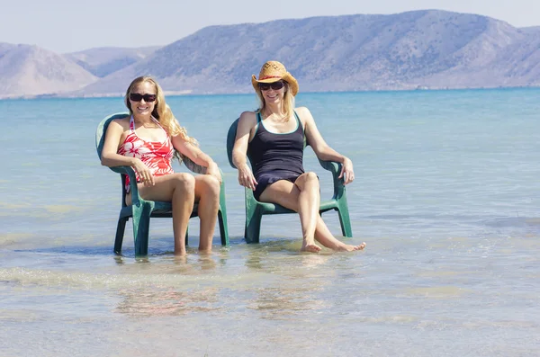 Två glada kvinnor avkoppling på stranden tillsammans — Stockfoto