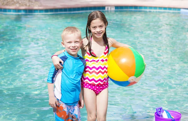 Niños jugando con pelota en la piscina — Foto de Stock