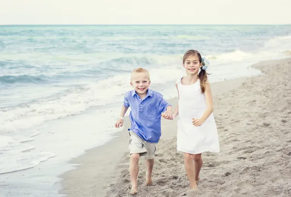 Sonriendo Niños corriendo en la playa — Foto de Stock