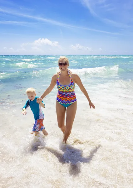 Família espirrando na praia juntos — Fotografia de Stock