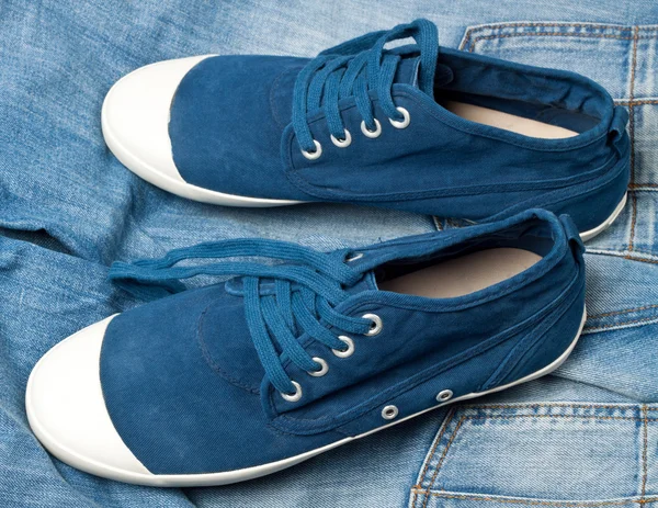 Une paire de nouvelles chaussures bleues sur un jean — Photo