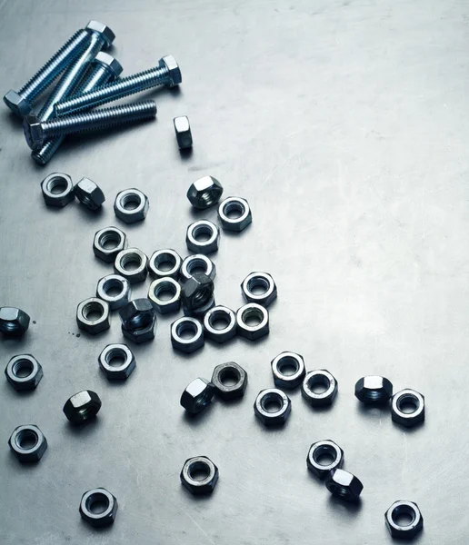 Nuts and screws on a metal plate — Stock Photo, Image