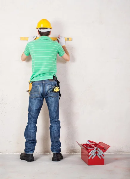 Construction worker using level and other tools — Stock Photo, Image