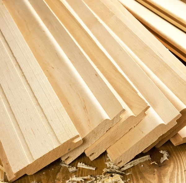 Wood planks are on a wooden board with sawdust — Stock Photo, Image