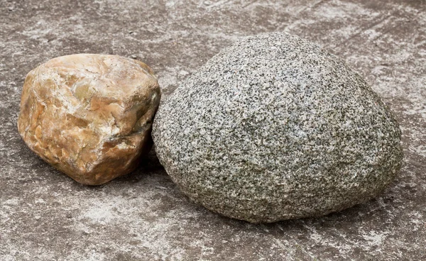 Камень на бетонной дорожке — стоковое фото