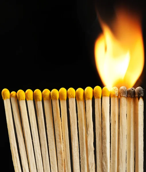 Burning matchsticks on black background — Stock Photo, Image