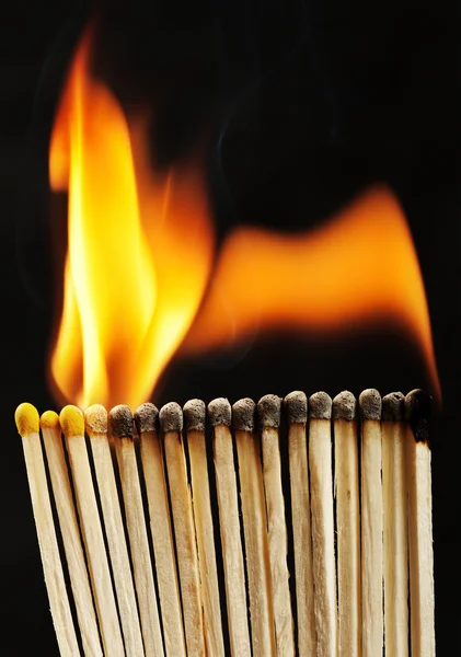 Burning matchsticks on black background — Stock Photo, Image