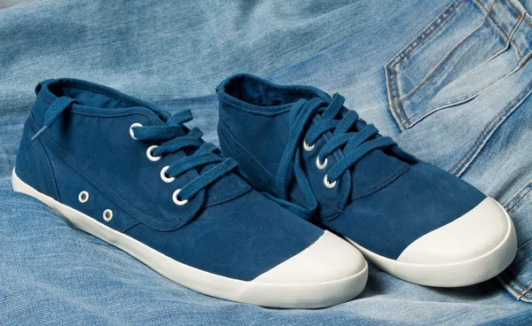 Un paio di nuove scarpe blu su un jeans — Foto Stock