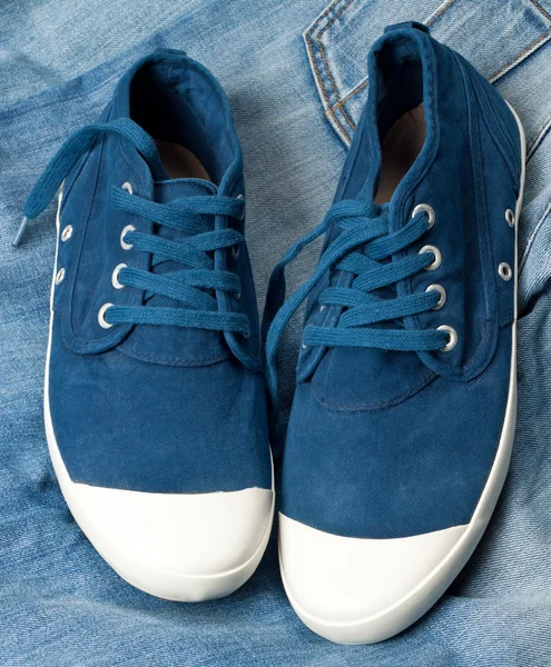 Une paire de nouvelles chaussures bleues sur un jean — Photo