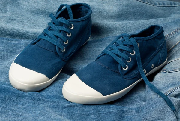Une paire de nouvelles chaussures bleues sur un jean — Photo