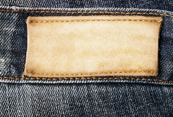 Kahverengi deri jeans etiket üzerinde kot pantolon diktim. — Stok fotoğraf