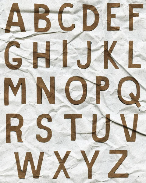 Lettres en alphabet marron sur papier froissé — Photo