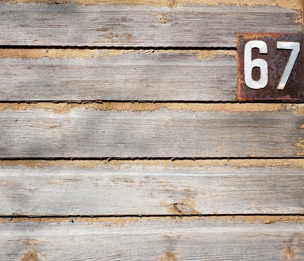 Parede de madeira grungy velha com números de casa — Fotografia de Stock