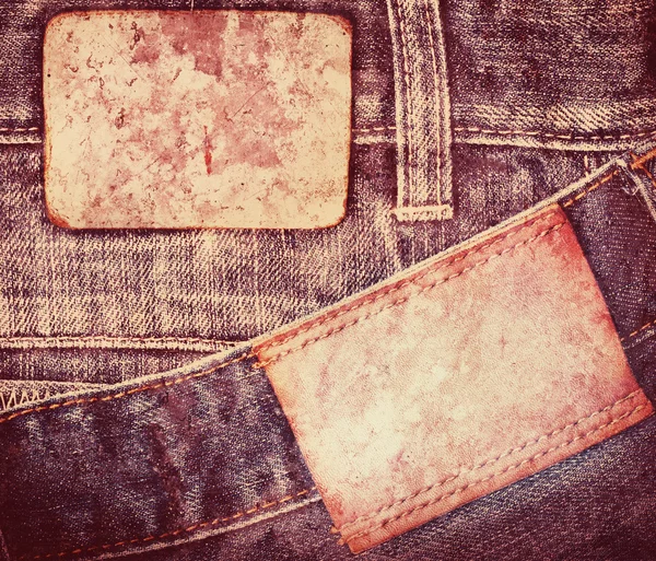 Grunge, gekleurd leder jeans label naaide op jeans. — Stockfoto