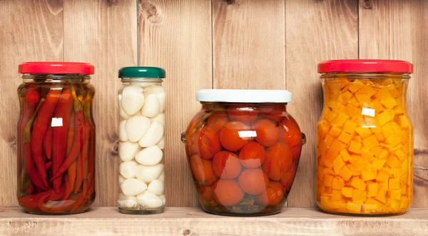 Preserved  vegetable on shelf near a brown wooden wall — Stock Photo, Image