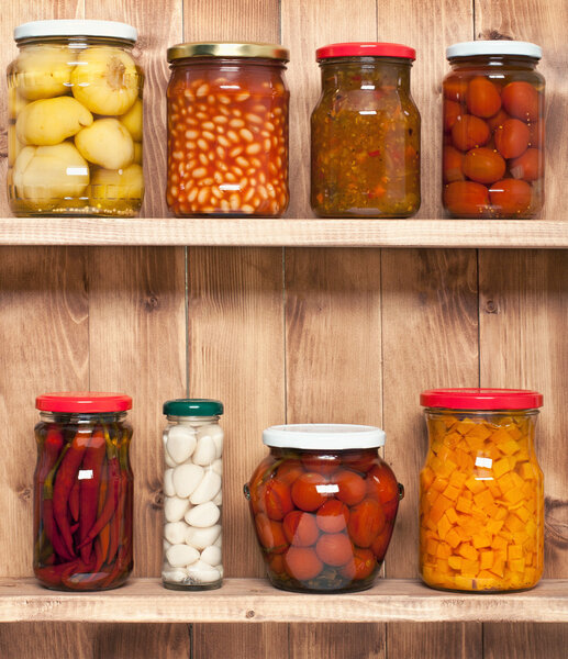 Preserved  vegetable on shelf near a brown wooden wall
