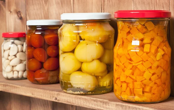 Preserved  vegetable on shelf near a brown wooden wall — Stock Photo, Image