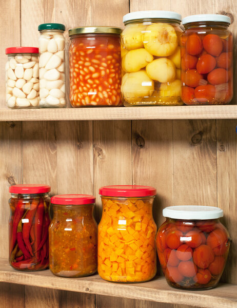 Preserved  vegetable on shelf near a brown wooden wall