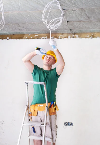 Électricien debout sur l'échelle avec couteau — Photo