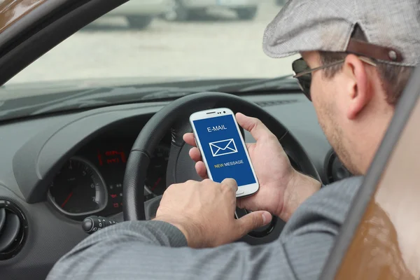 Businessma checking email in a car — Stock Photo, Image