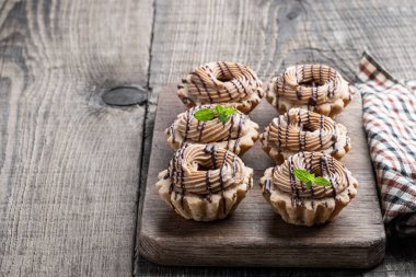 Krem şantili kısa hamurlu pasta ve ahşap masada ceviz. 