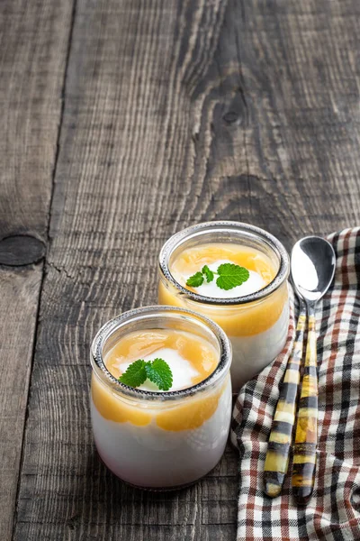 Yogurt Bianco Cremoso Con Purea Fruttata Gialla Vasetto Tavolo Legno — Foto Stock