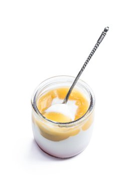 Beyaz kremalı yoğurt ve küçük kavanozda sarı meyveli püre. 