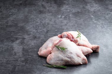 Gri taşlı arka planda çiğ tavuk butları. 