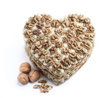 Ev yapımı kalp şeklinde katmanlı kek. Beyazın üzerinde ceviz ile süslenmiş. 