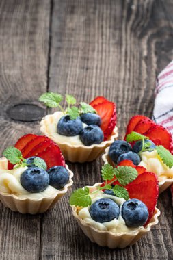 Tahta masada taze meyveli tartlar. 