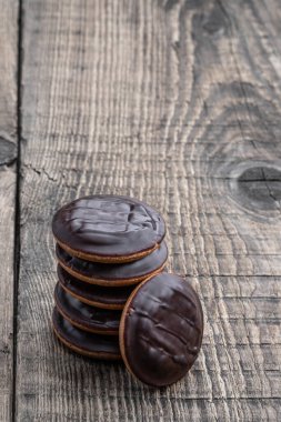 Siyah çikolatayla kaplanmış ve ahşap masada marmelatla dolu Jaffa kek kurabiyeleri. 