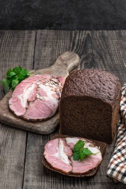 Domuz eti dilimleri. Çavdar ekmeğine işlenmiş et. Tahta masada. 