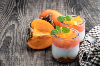 Tahta masada cam kavanozlarda hurma dilimleri olan beyaz meyveli yoğurt. 