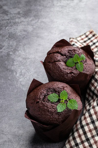 Dark  chocolate muffin stuffed with jam on gray background
