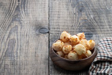 Kırsal masadaki ahşap kasede kızarmış küçük peynir topları. 