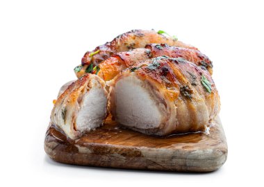 Chicken  breasts wrapped in bacon on wooden board isolated on white 