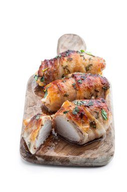 Chicken  breasts wrapped in bacon on wooden board isolated on white 
