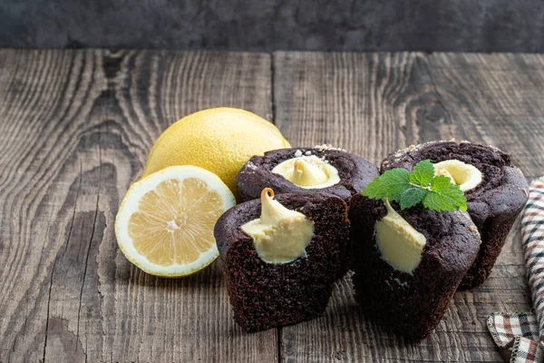 Chocolate  muffins with lemon cream filling on wooden table