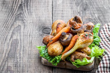 Ahşap tahtada baharat ve bitkilerle fırında sebze. 