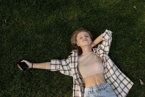 Young caucasian woman lies on green grass — Stock Photo, Image