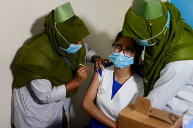 Bangladeşli öğrenciler, 1 Kasım 2021 'de Bangladeş' in Motijheel bölgesindeki İdeal Okul ve Kolej Merkezi 'nde Pfizer COVID-19 aşısının ilk dozunu almayı beklerken kayıt kartlarıyla ayakta duruyorlar..