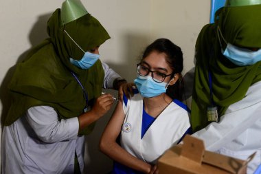 Bangladeşli öğrenciler, 1 Kasım 2021 'de Bangladeş' in Motijheel bölgesindeki İdeal Okul ve Kolej Merkezi 'nde Pfizer COVID-19 aşısının ilk dozunu almayı beklerken kayıt kartlarıyla ayakta duruyorlar..