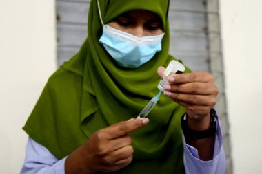 Bangladeşli öğrenciler, 1 Kasım 2021 'de Bangladeş' in Motijheel bölgesindeki İdeal Okul ve Kolej Merkezi 'nde Pfizer COVID-19 aşısının ilk dozunu almayı beklerken kayıt kartlarıyla ayakta duruyorlar..