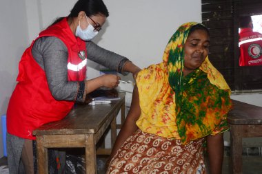 Bangladeş, Dhaka 'daki Karail gecekondu mahallesinde 16 Kasım 2021' de Covid-19 Coronavirus 'a karşı bir doz AstraZeneca / Oxford aşısı alan bir kadın görülüyor..