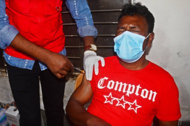 Bir gecekondu çocuğu 16 Kasım 2021 'de Bangladeş, Dhaka' daki Karail gecekondu mahallesinde Covid-19 Coronavirus 'a karşı bir doz AstraZeneca / Oxford aşısı alır..