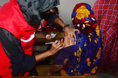 Bangladeş, Dhaka 'daki Karail gecekondu mahallesinde 16 Kasım 2021' de Covid-19 Coronavirus 'a karşı bir doz AstraZeneca / Oxford aşısı alan bir kadın görülüyor..